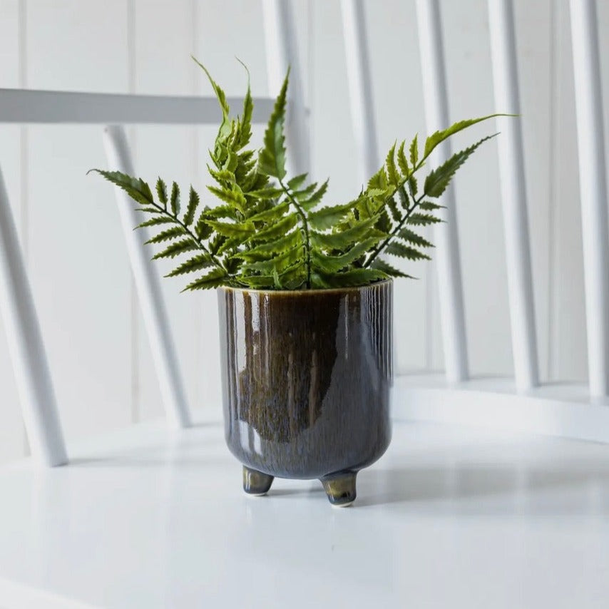 Make your plant pop in this footed ceramic pot. The modern shape features a navy blue reactive glaze that will add a splash of color to your decor.